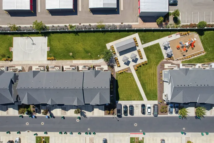 Community amenities featuring a basketball court, playground, shaded seating areas, and open green space