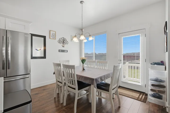Dining area with big windows looking out to the open green space, and door to the backyard.