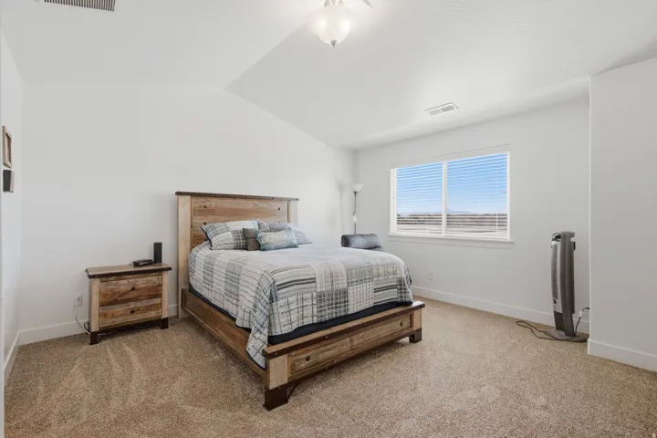 Carpeted flooring with a large window, white window blinds, and white walls