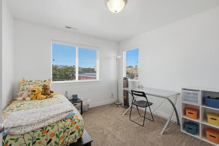 Neutral wall paint, carpet flooring, windows with blinds, and a ceiling-mounted light fixture