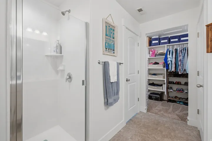 Walk-in shower with clear glass enclosure and chrome fixtures