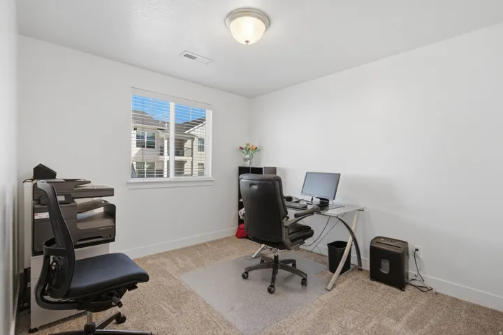 Neutral wall finish, single window with horizontal blinds, flush mount ceiling light, and carpeted flooring