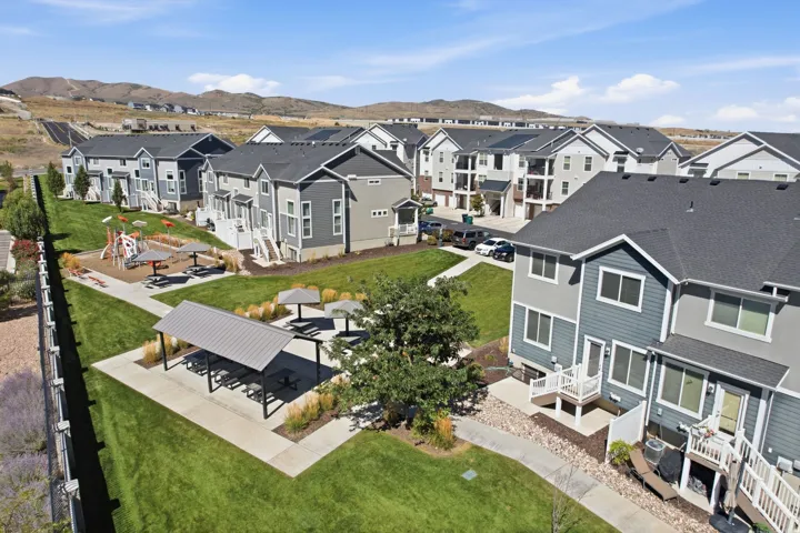 Backyard is connected to the  green space featuring a covered pavilion, playground area, and multiple shaded seating areas