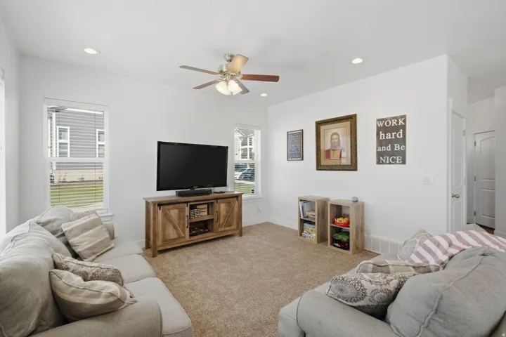 Recessed lighting, ceiling fan with integrated lighting, multiple windows with blinds, and light-toned wall finishes