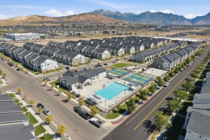 Residential neighborhood featuring multiple townhomes, a community swimming pool, two tennis courts, and a clubhouse