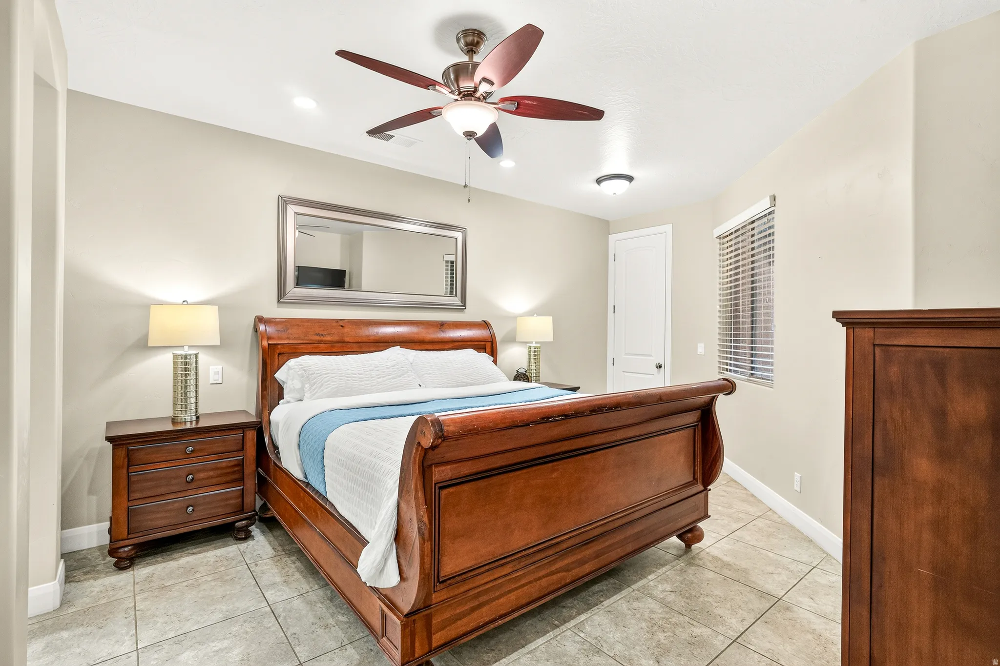 Ceiling fan with integrated lighting, recessed ceiling lights, tiled flooring, window with blinds, and arched doorway