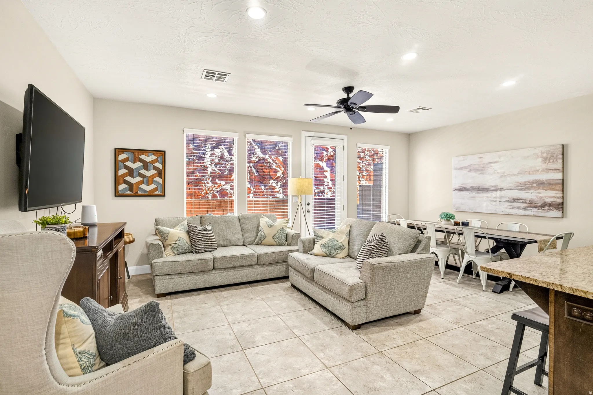 Tile flooring throughout, recessed lighting, ceiling fan, multiple windows with blinds, and a built-in wall-mounted television