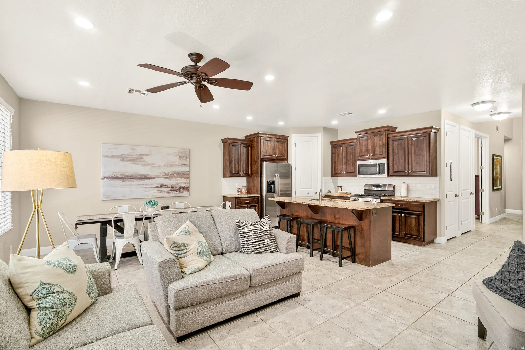 Open-concept living space featuring a ceiling fan, recessed lighting, and tile flooring