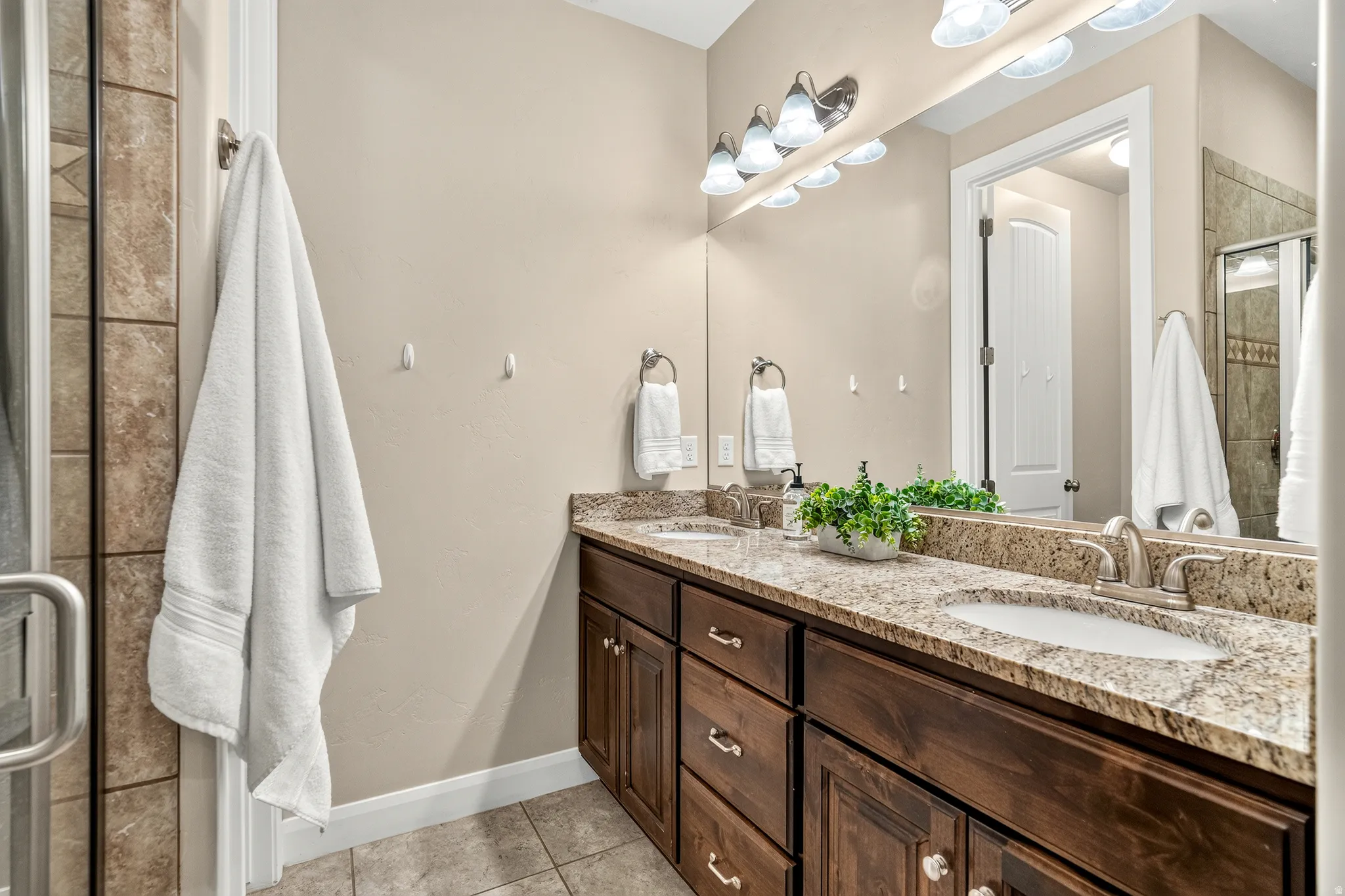 Dual vanity with undermount sinks, stone countertop, and wood-finish cabinetry