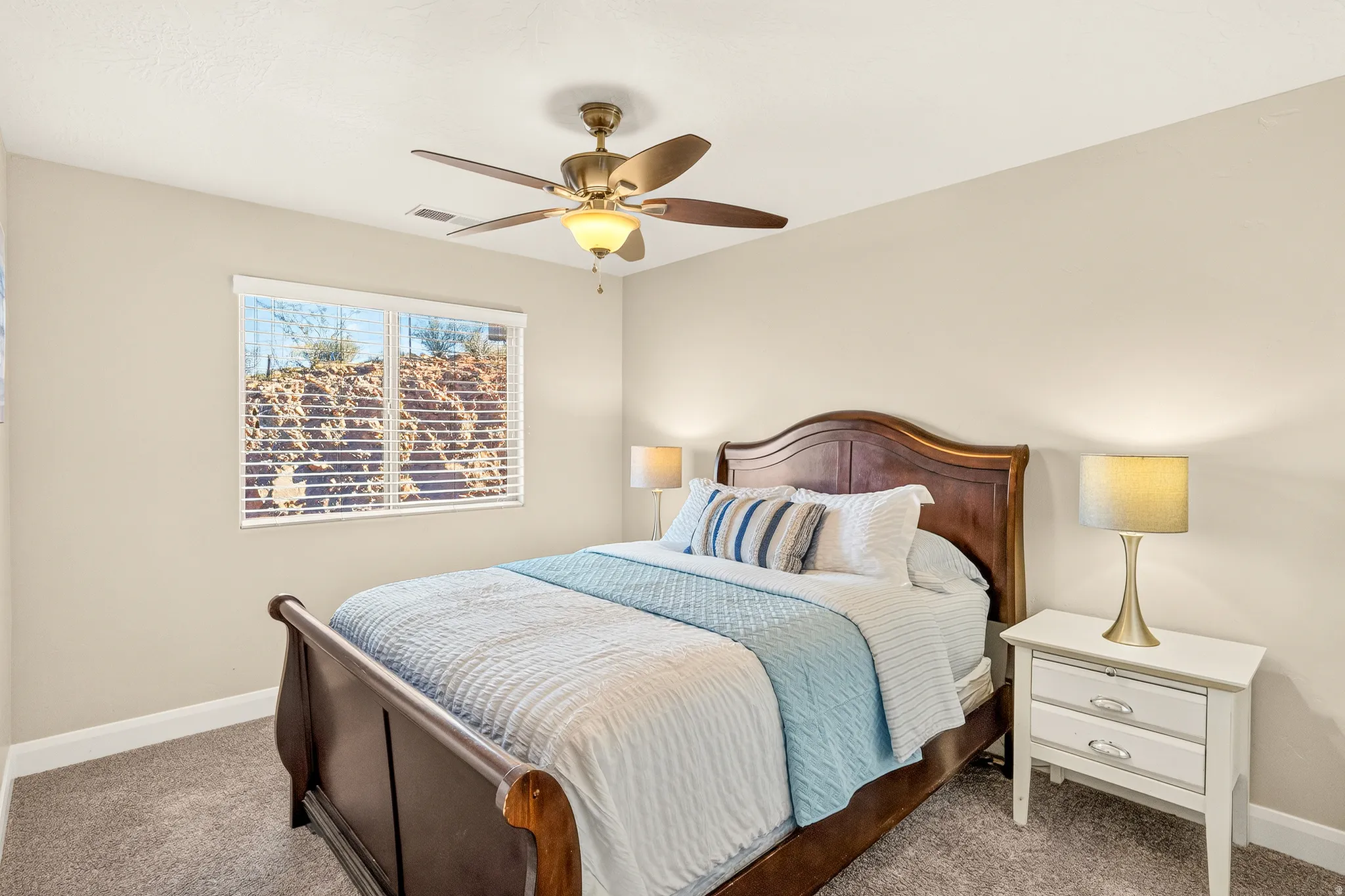 Recessed window with horizontal blinds, ceiling fan with integrated lighting, and neutral wall paint