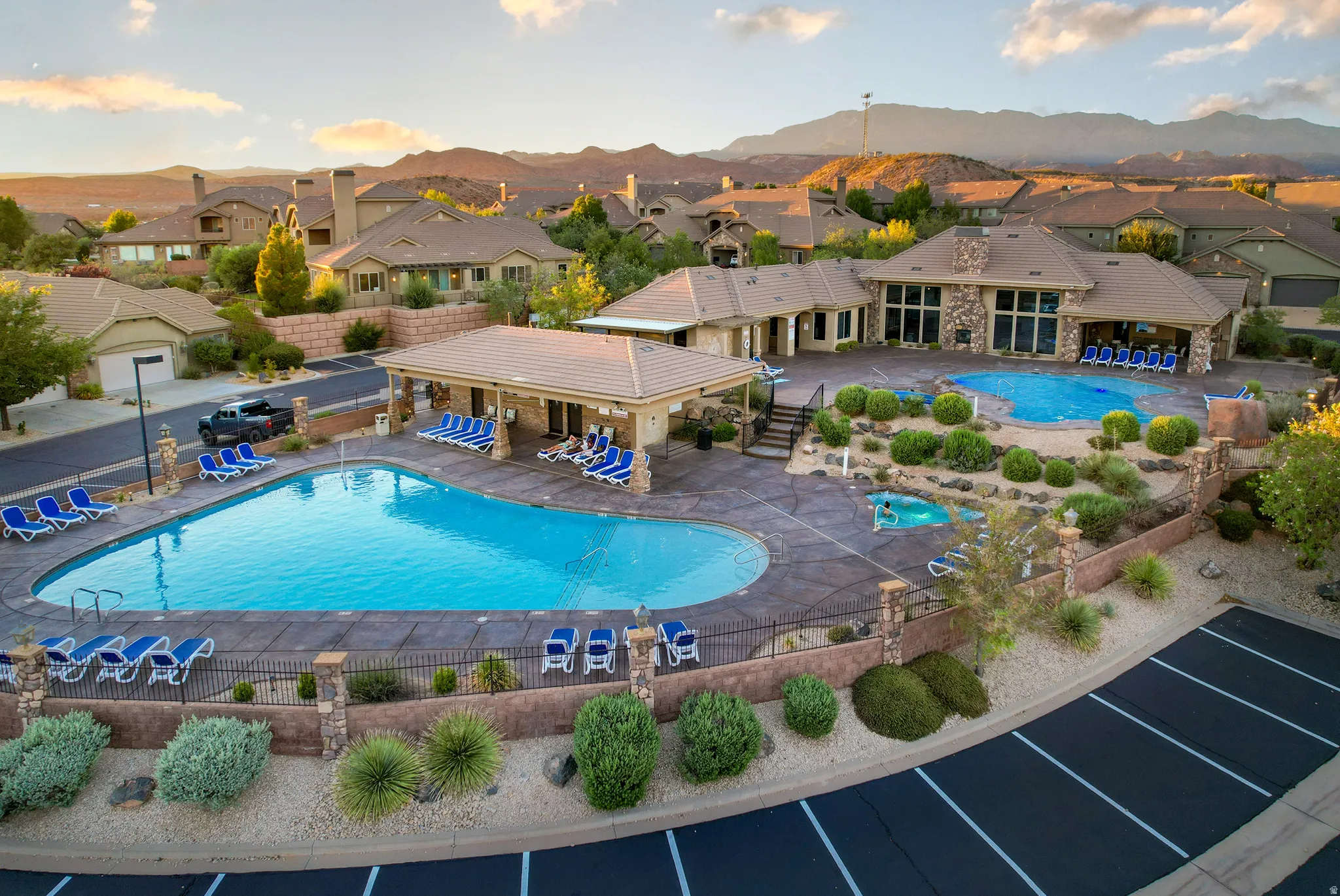 Community amenity center featuring two pools, covered lounge areas, and a spa