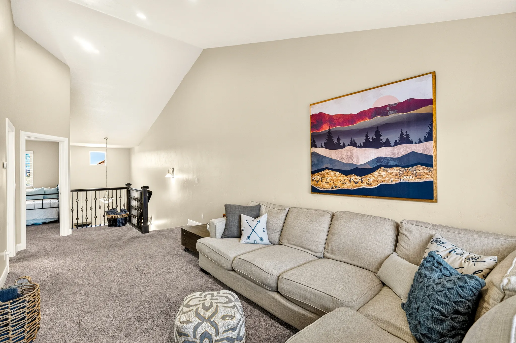 Vaulted ceilings, recessed lighting, and soft gray carpeting