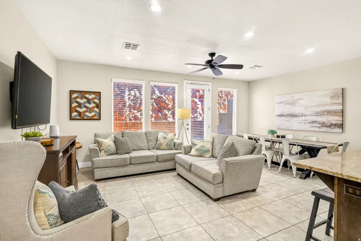 Tile flooring throughout, recessed lighting, ceiling fan, multiple windows with blinds, and a built-in wall-mounted television