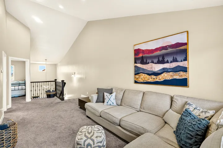 Vaulted ceilings, recessed lighting, and soft gray carpeting