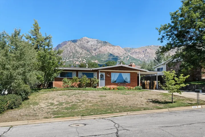 Brick exterior with a carport and mountain backdrop
