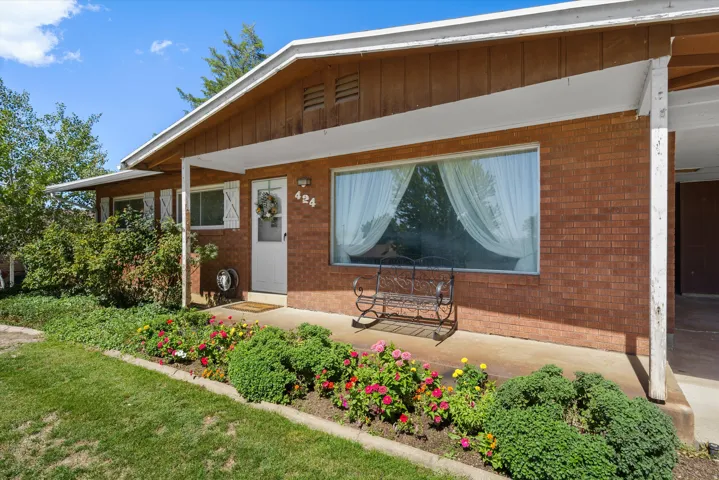 Brick exterior with a covered entry, white front door, and a large picture window