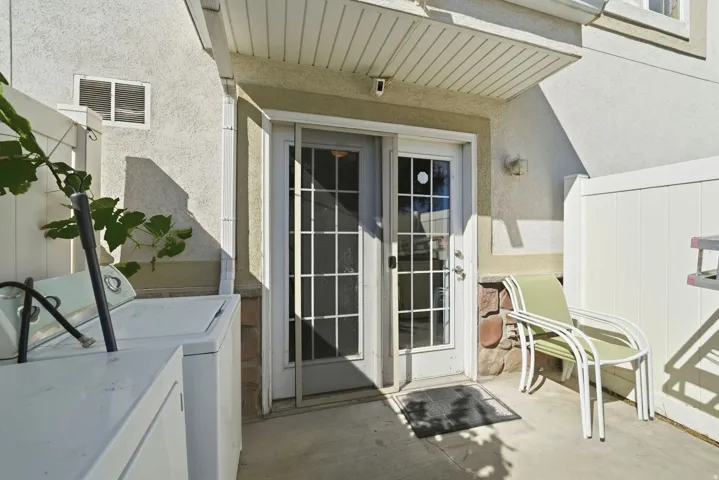 Private outdoor patio with stone accent wall and white privacy fencing