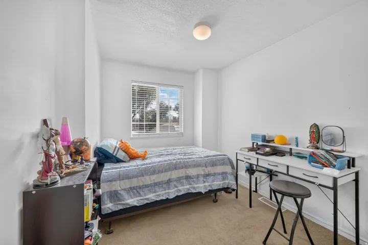 Carpeted flooring, white painted walls, window with blinds, and ceiling-mounted light fixture