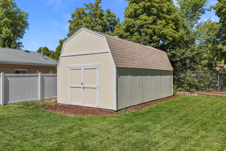 Gable-roof shed with double doors, shingle roofing, and wood siding