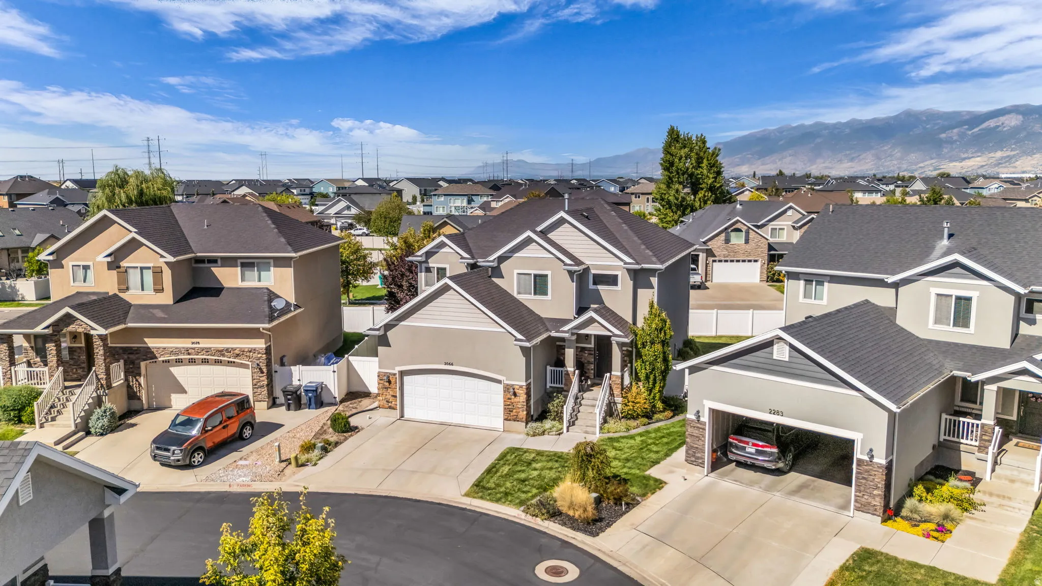 Contemporary suburban residence featuring a two-car garage, manicured lawn, and paved driveway