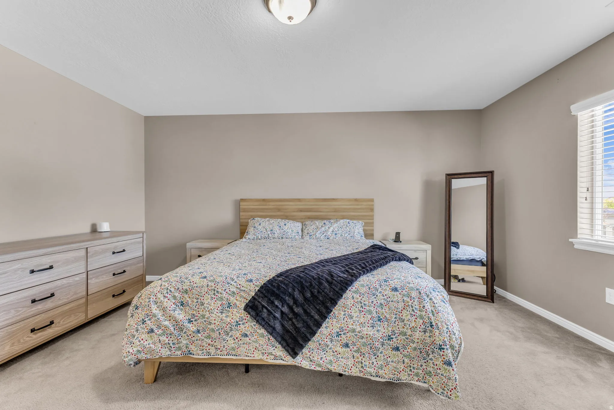 Carpeted bedroom with neutral wall tones and a flush-mount ceiling light