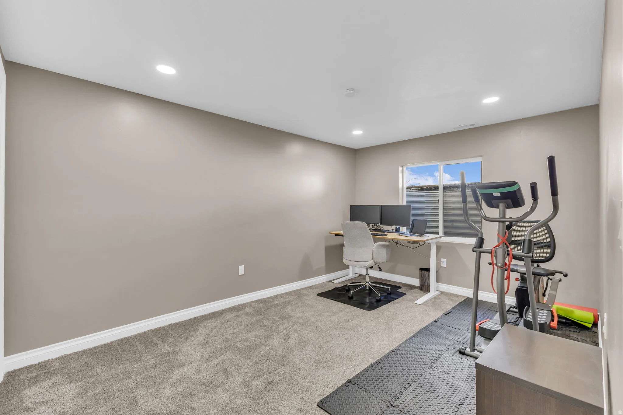 Recessed lighting, neutral wall paint, white trim, window with blinds, and carpet flooring