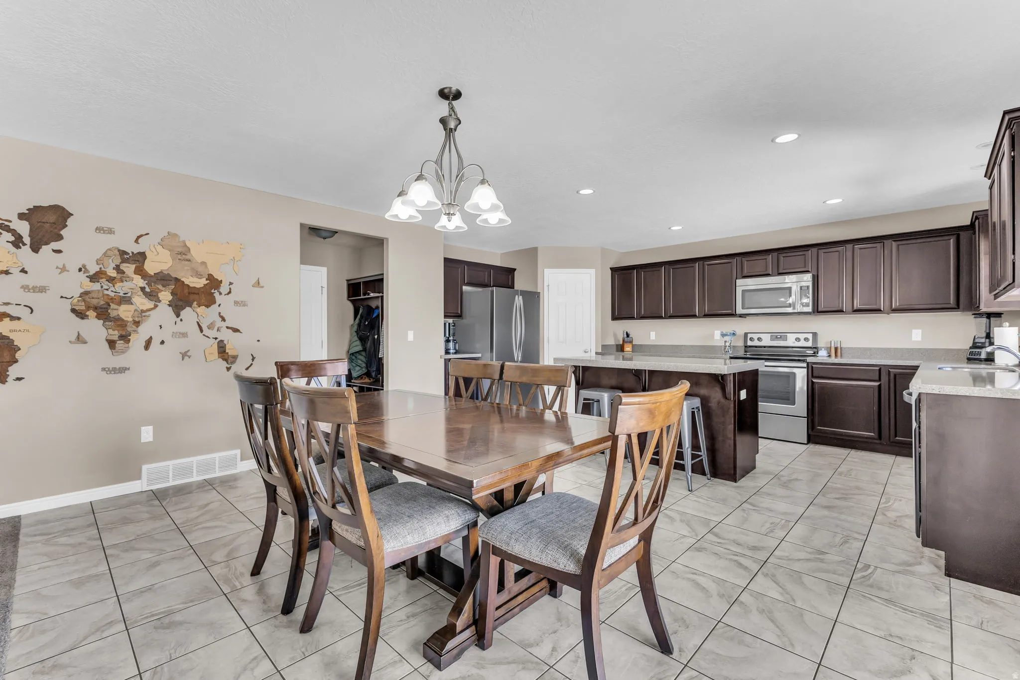 Open-concept dining area featuring tile flooring and a chandelier