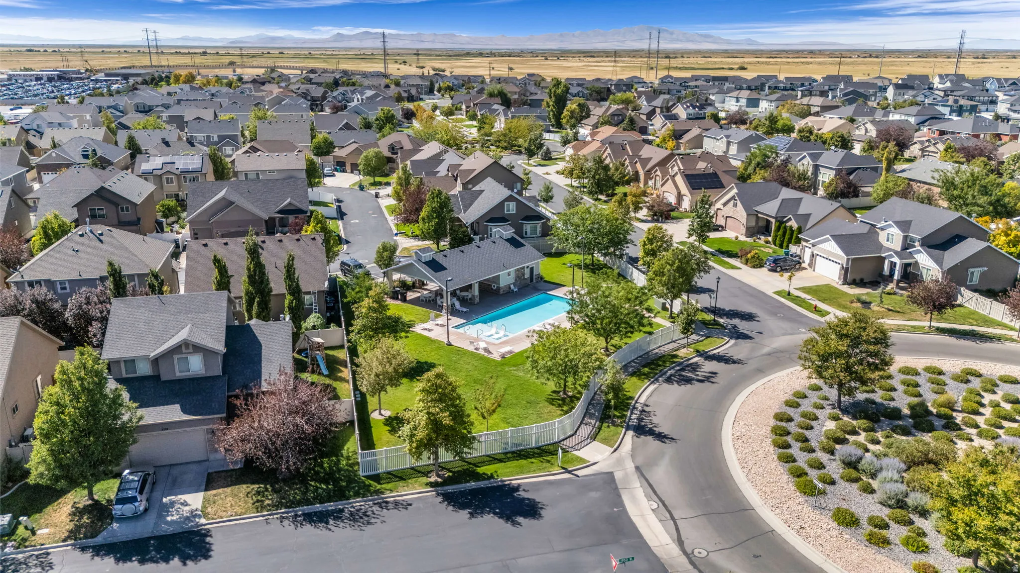Residential neighborhood with established homes, mature trees, and a distant mountain range