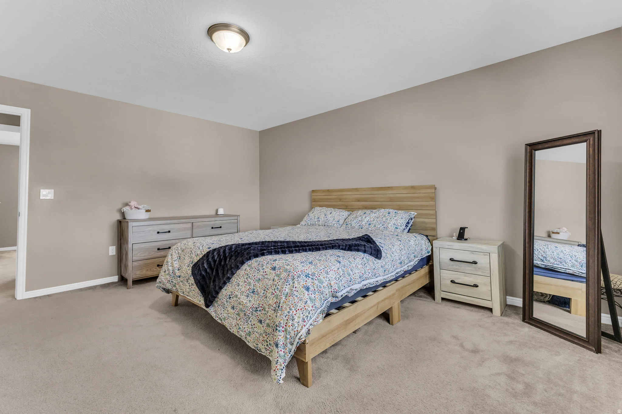 Neutral-toned walls complement the soft carpeting