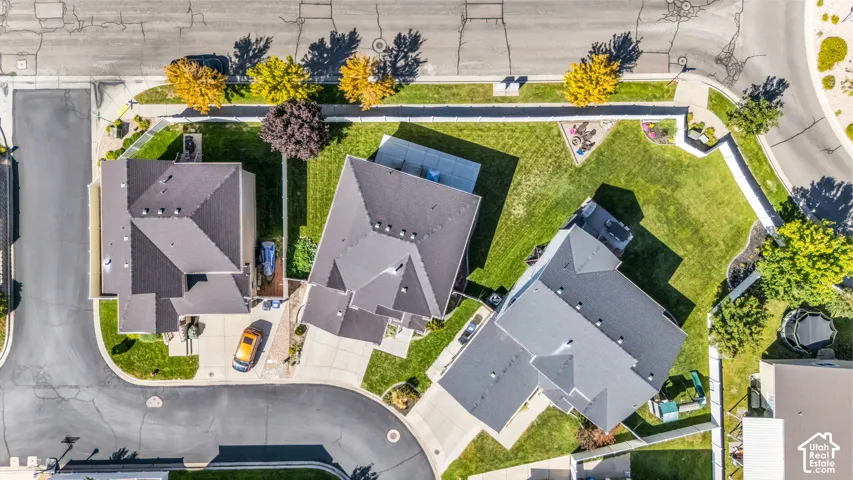 Aerial perspective showcasing multiple properties, street access, and established landscaping