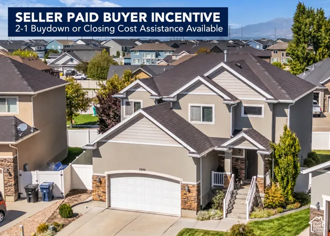 Multi-level exterior featuring stucco and stone accents, an attached garage, and a covered entry with steps