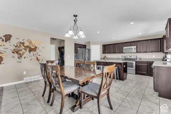 Open-concept dining area featuring tile flooring and a chandelier