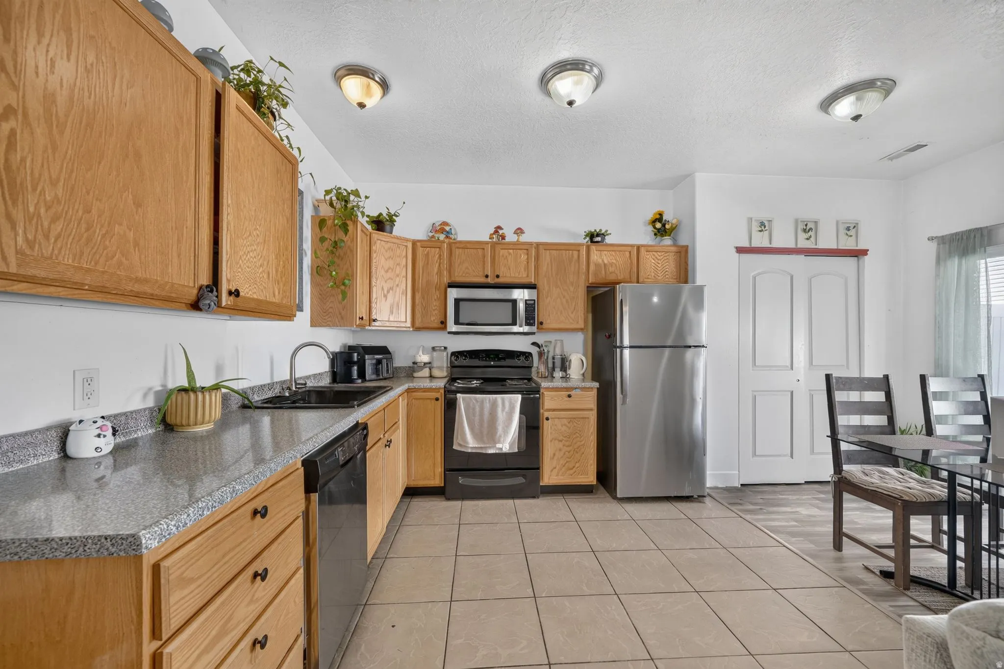 Kitchen featuring wood-finish cabinetry, solid surface countertops, a stainless steel refrigerator, and a built-in microwave