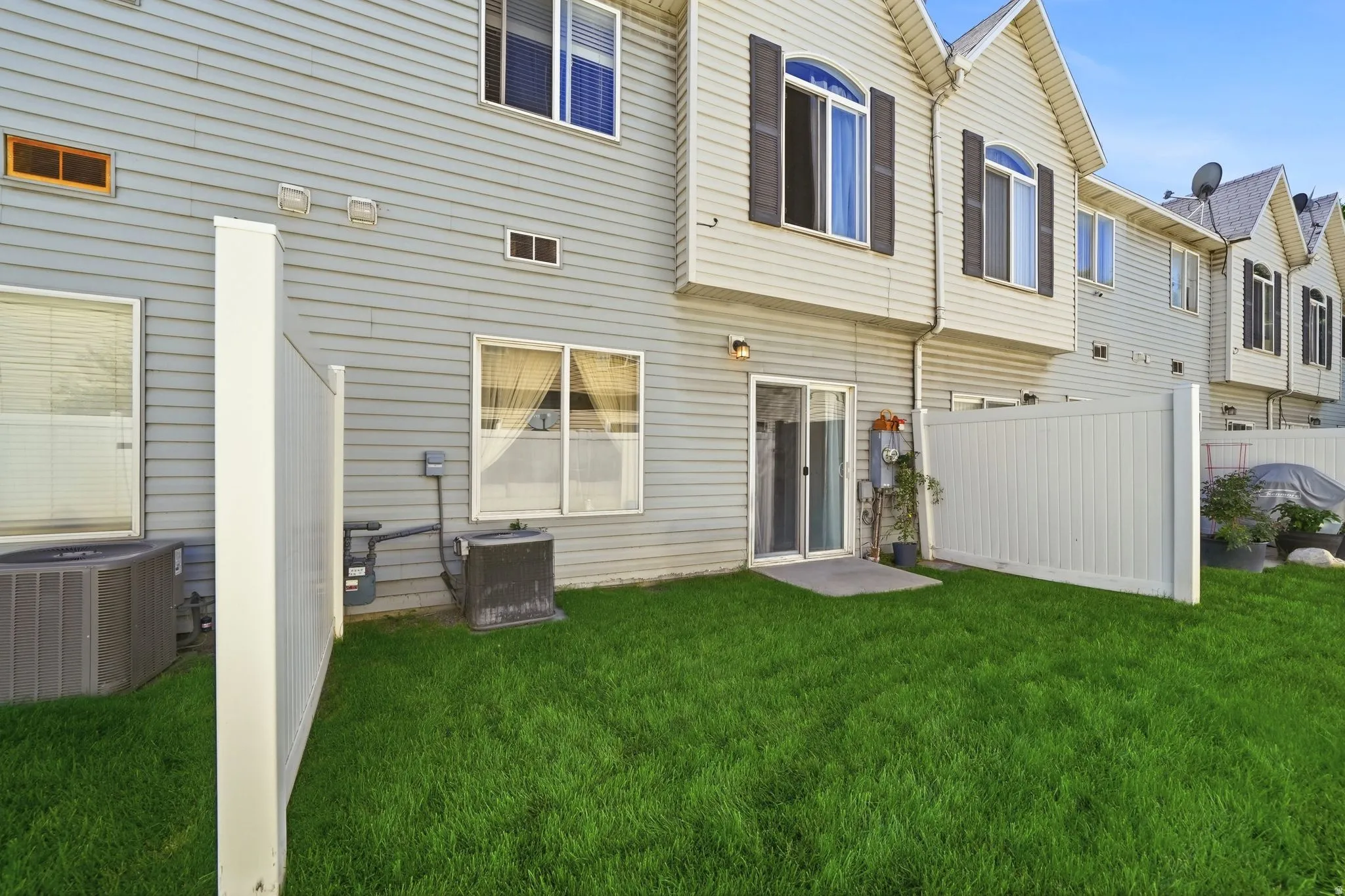 Enclosed patio with direct outdoor access, a level lawn, and privacy fencing