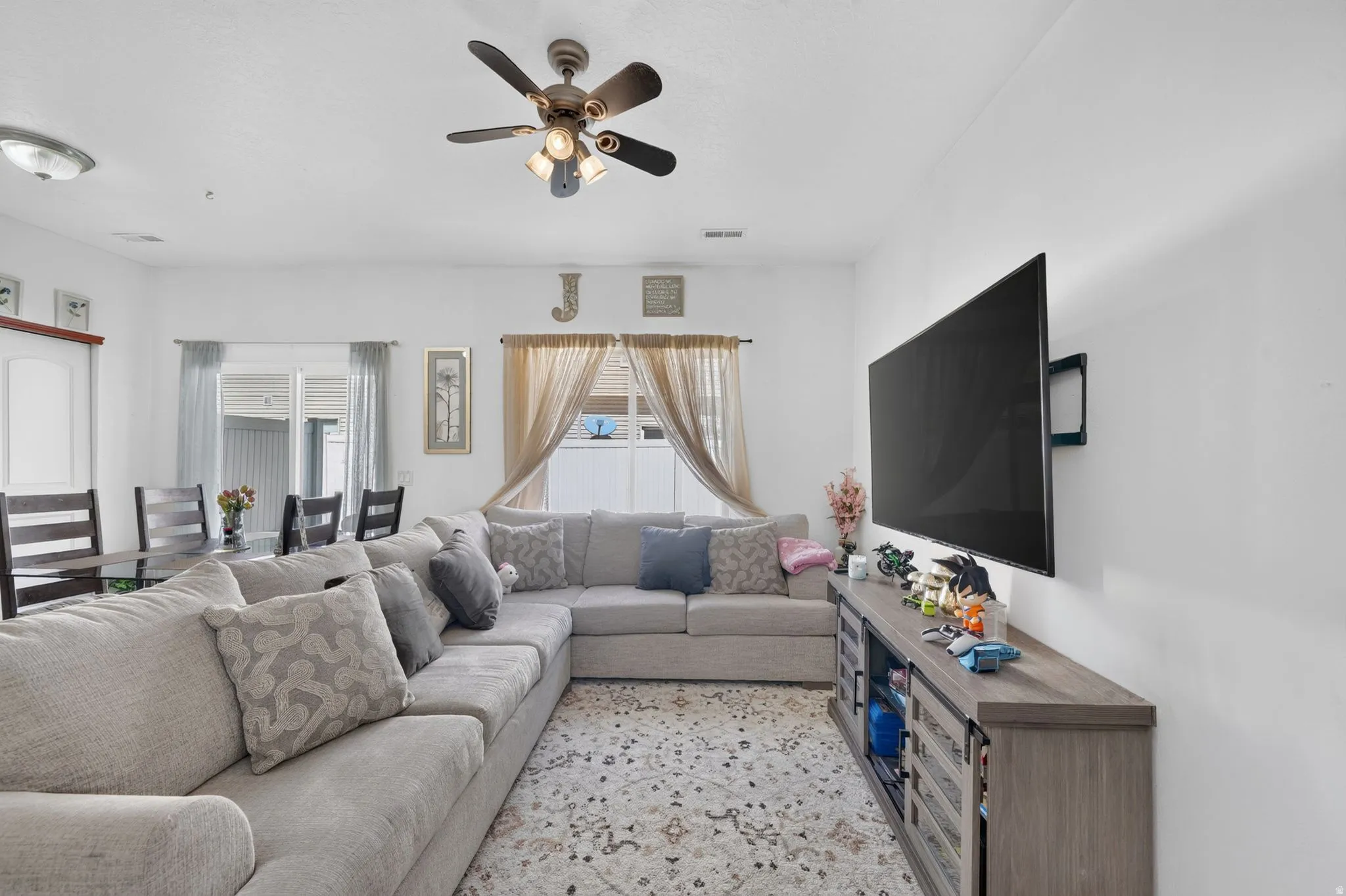 Integrated living and dining space with a ceiling fan