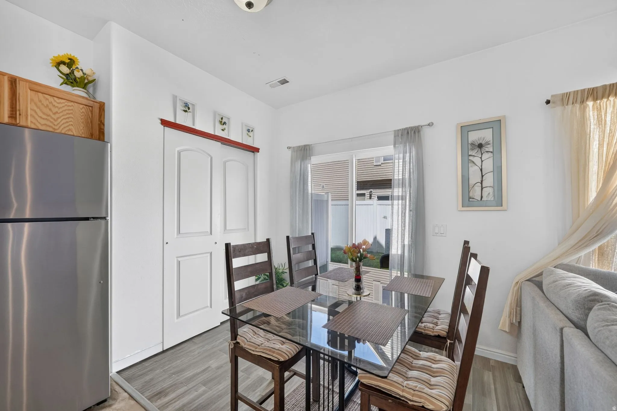 Wood-finish flooring throughout, bright white walls, and a sliding glass door