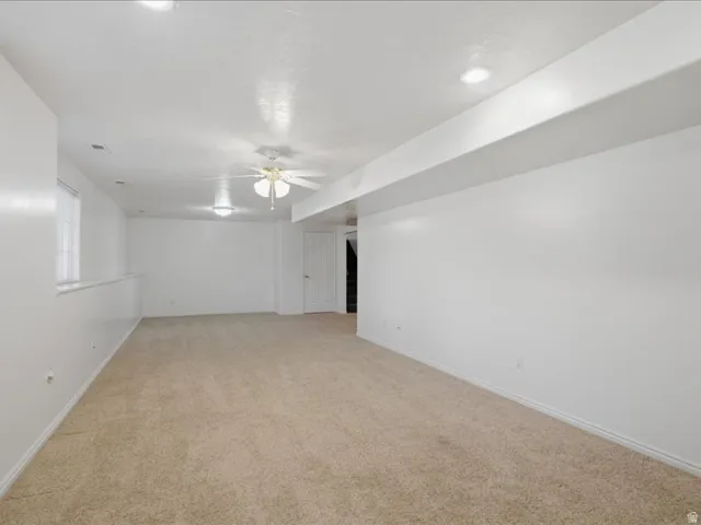 Expansive room featuring recessed lighting, a ceiling fan, and neutral carpeting