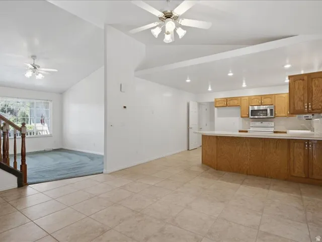 Kitchen featuring wood cabinetry, stainless steel microwave, and white countertops