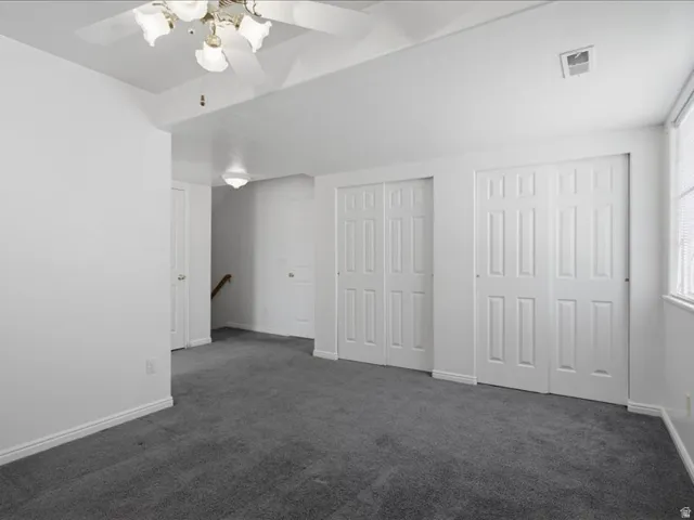 Recessed ceiling fan, textured white walls, gray carpet flooring, and white paneled bi-fold closet doors