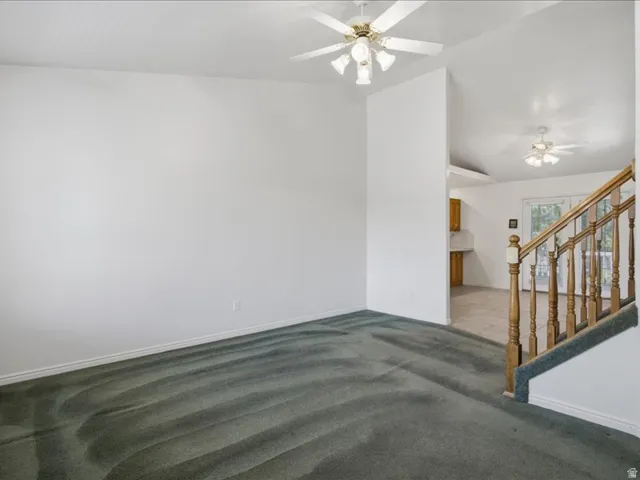 Vaulted ceilings with ceiling fans, wood handrails, and a tile floor entry
