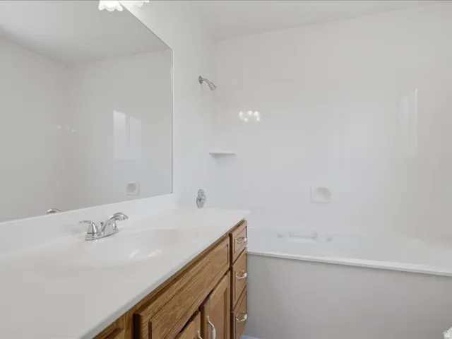 Bathroom vanity with an integrated sink, polished chrome faucet, and wood-finish cabinetry