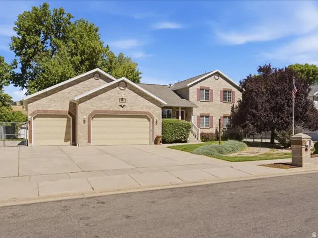 Brick-clad exterior with red shutters, a two-car garage, and an attached single-car garage