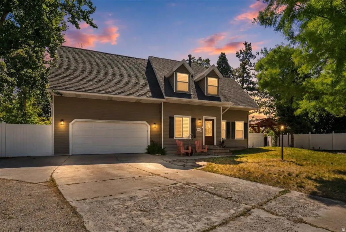 Two-story exterior with dormer windows, attached garage, and a concrete driveway