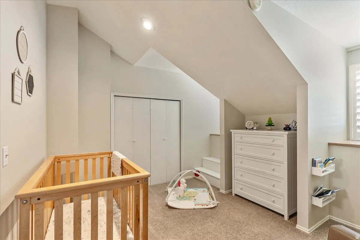 Sloped ceiling architecture, recessed lighting, carpeted flooring, bi-fold closet doors, and interior plantation shutters
