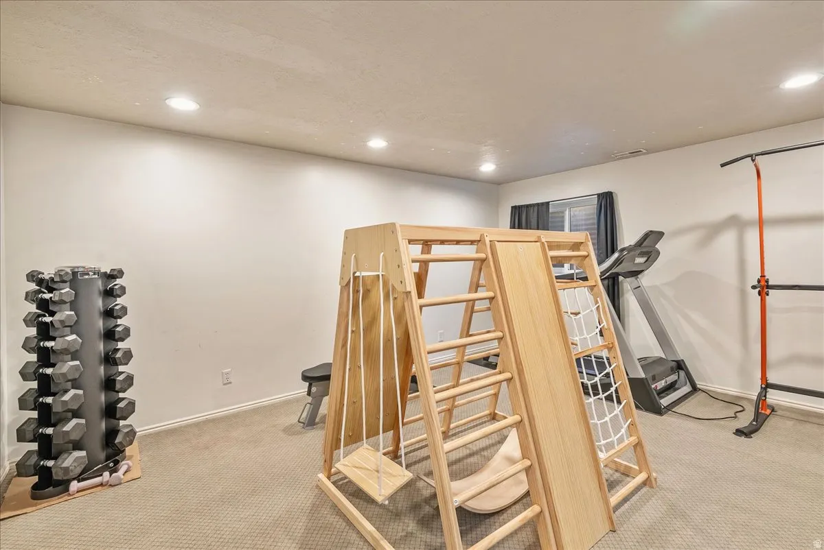 Recessed lighting illuminates a carpeted room with neutral wall tones