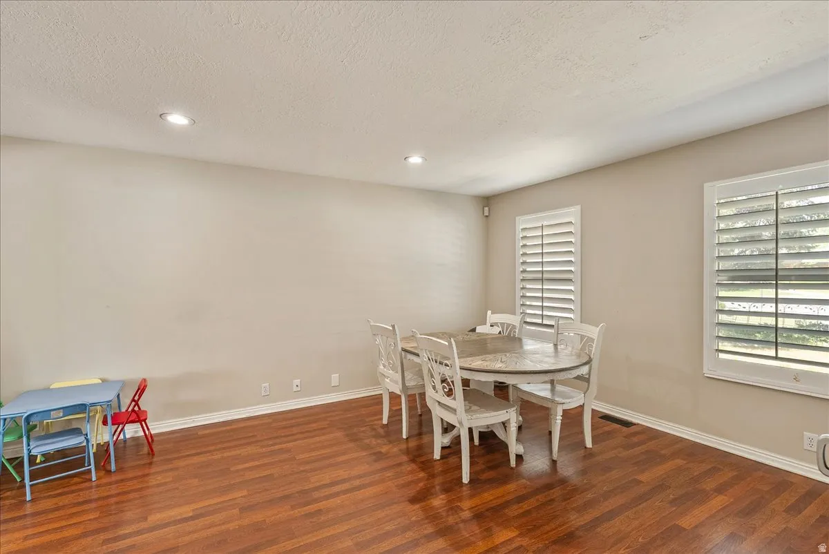 Recessed ceiling lighting, wood-finish flooring, and white window shutters