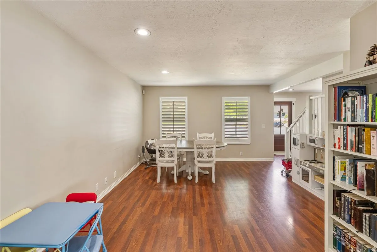 Wood-finish flooring, recessed lighting, and white plantation shutters complement the neutral wall tones