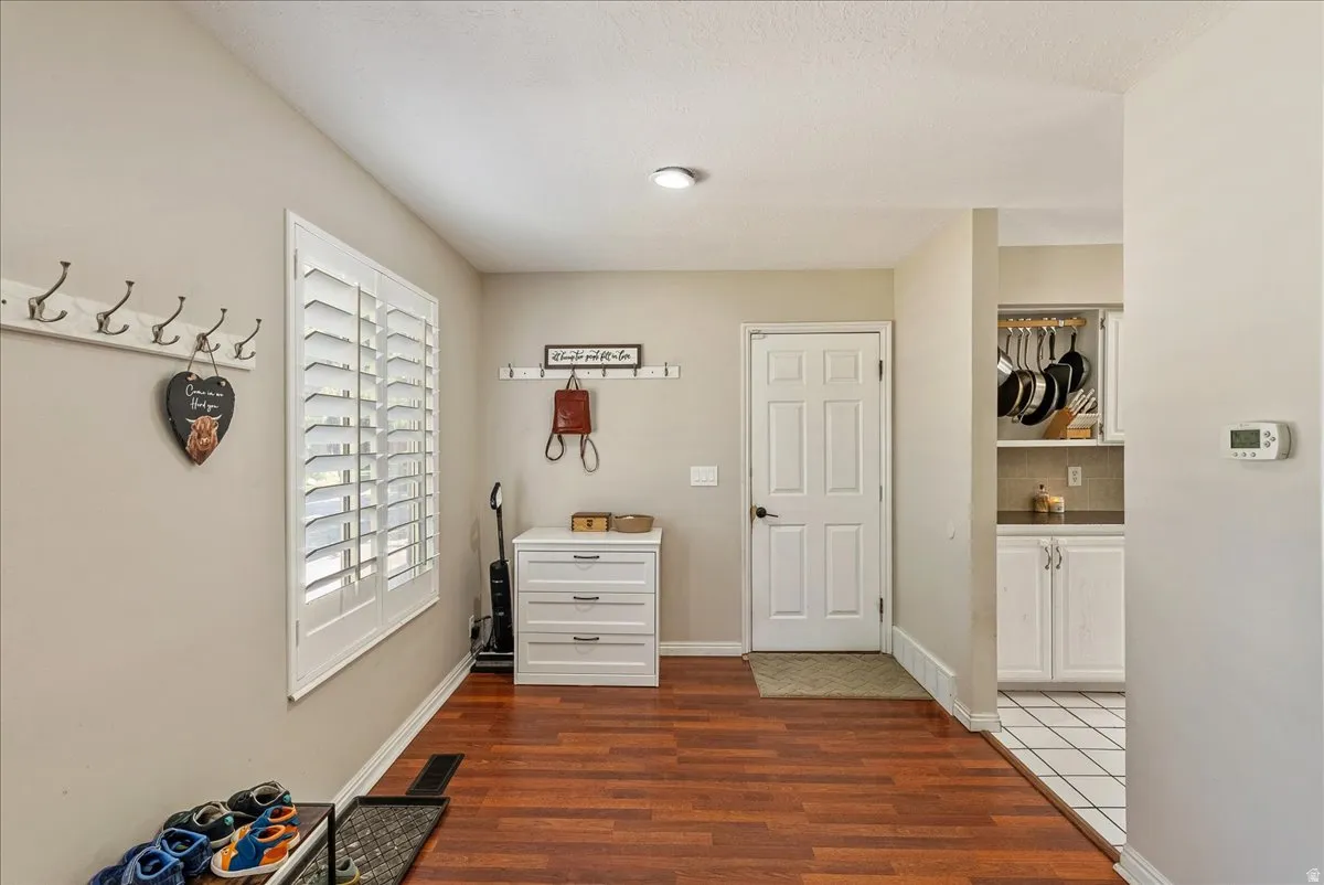 Hardwood-finish flooring, plantation shutters, recessed lighting, and a white paneled door