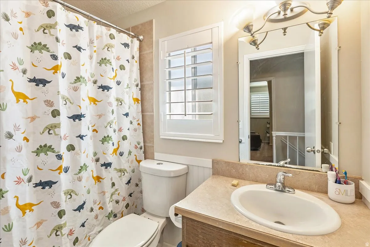 Recessed bathtub with shower rod, toilet, and vanity with built-in sink