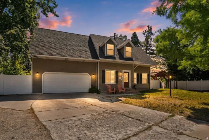 Two-story exterior with dormer windows, attached garage, and a concrete driveway